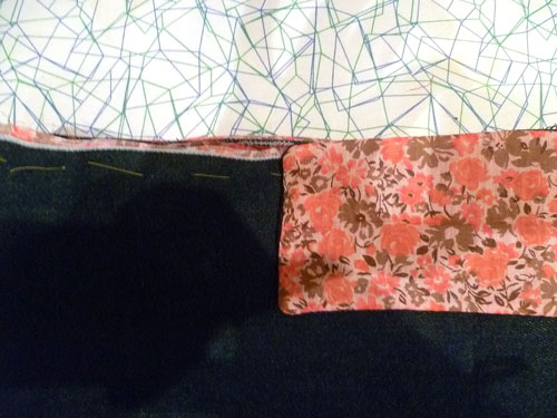 Red and pink floral fabic pinned around denim forming the linging of the backpack