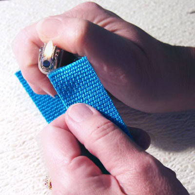 Edges of webbing being burned by a lighter