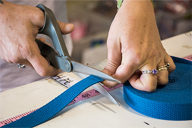 Blue webbing being cut to measured length