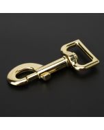 A golden brass snap hook on a black background