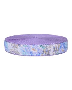 Blossoms appear in shades of pale blue and lavender, with soft green and muted gold leaves. It has a solid lavender edges and backing