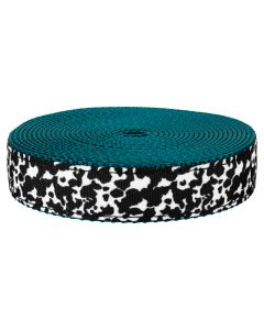 Black and white dairy cow print against teal nylon
