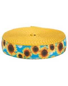 Grosgrain ribbon with a blue sky with white fluffy clouds and bright sunflowers scattered throughout printed on it sewn onto gold colored nylon webbing