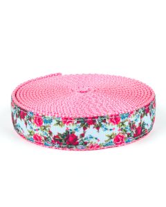 A sky blue background with old timey roses printed onto grosgrain ribbon sewn onto pink nylon webbing