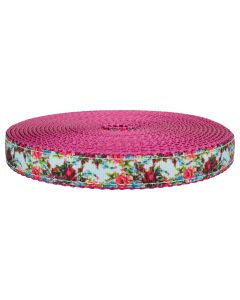 A blue grosgrain ribbon with roses printed on it sewn onto rose colored nylon webbing