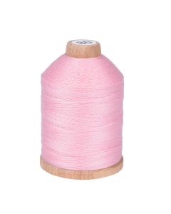 A wooden spool with pink cotton thread on it