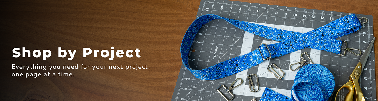 Tools and clips being used to fashion something from blue paisley webbing