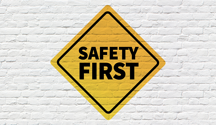 Safety first caution sign painted on a brick wall