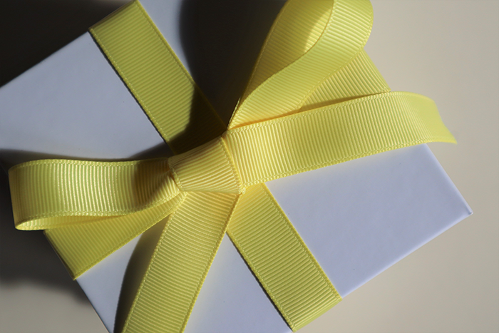 Pale blue package with a yellow ribbon