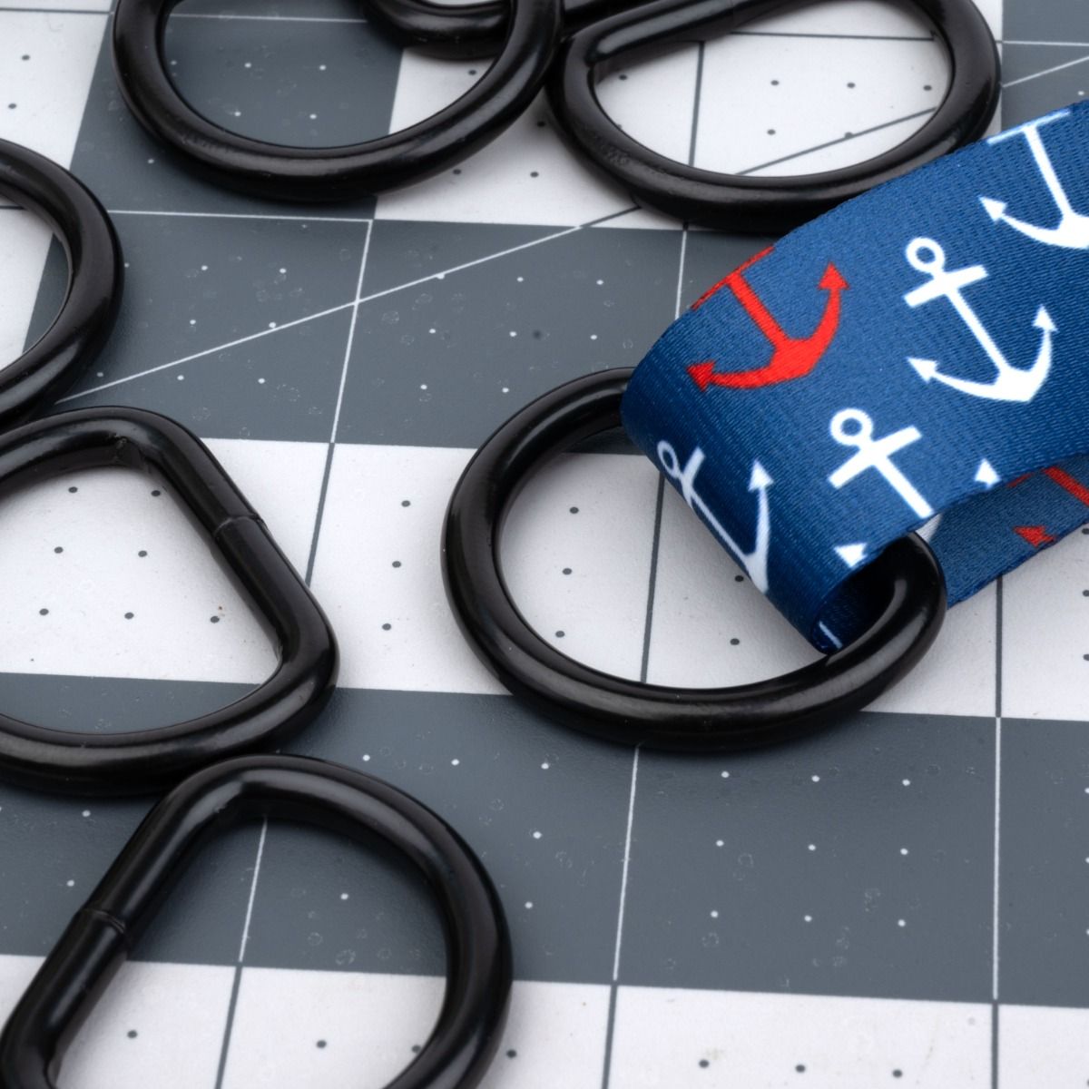 black d-rings with one attached to anchor patterned webbing