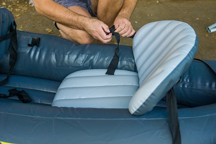 Kayaker repairing a nylon strap on his kayak